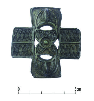 An intricate cruciform horse strap-mount with relief decoration
