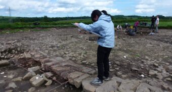 Person drawing while standing at an archaeological site