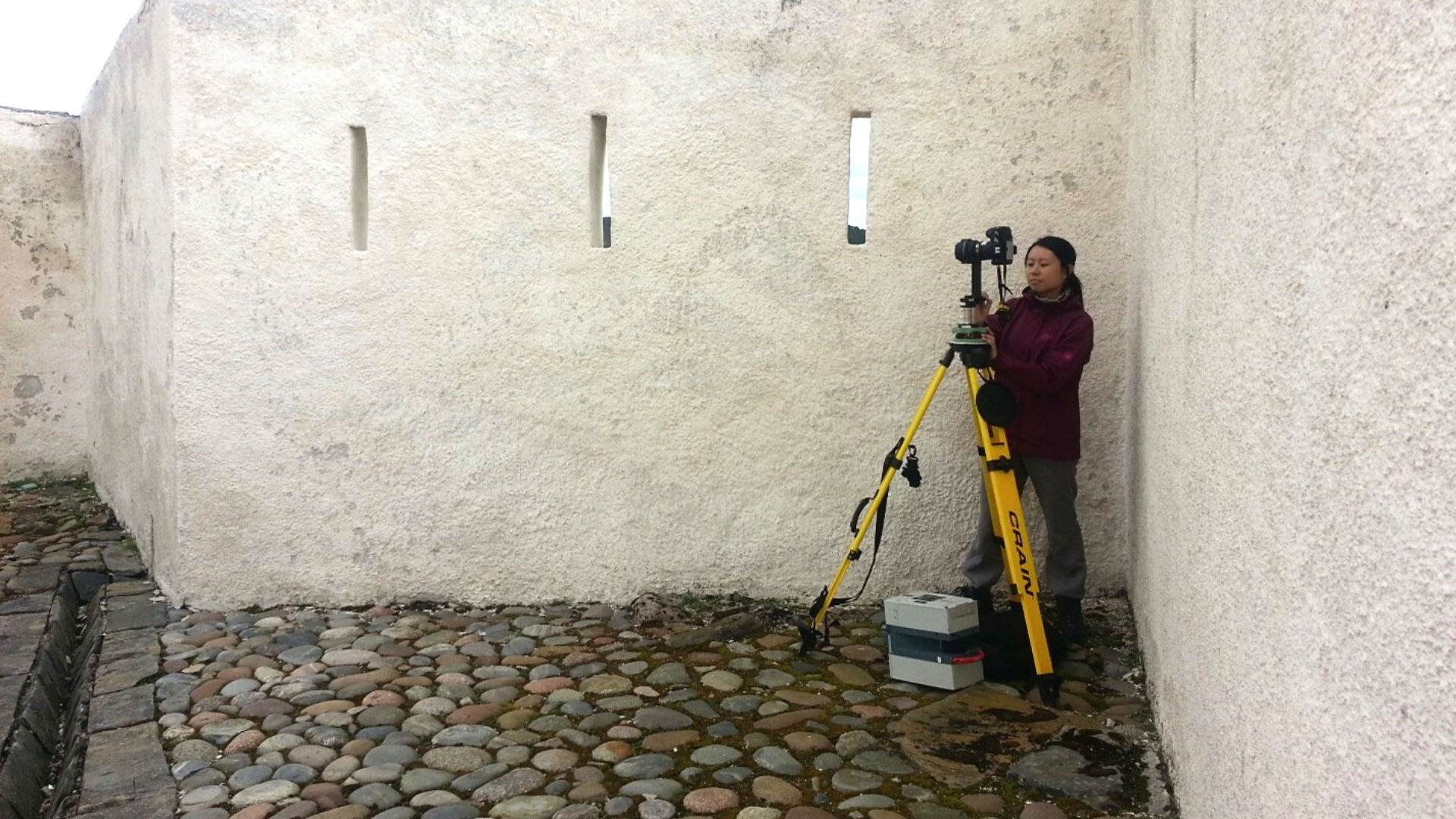 Person taking a photograph in an old building