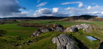 Photo of a stony outcrop looking over a green glen