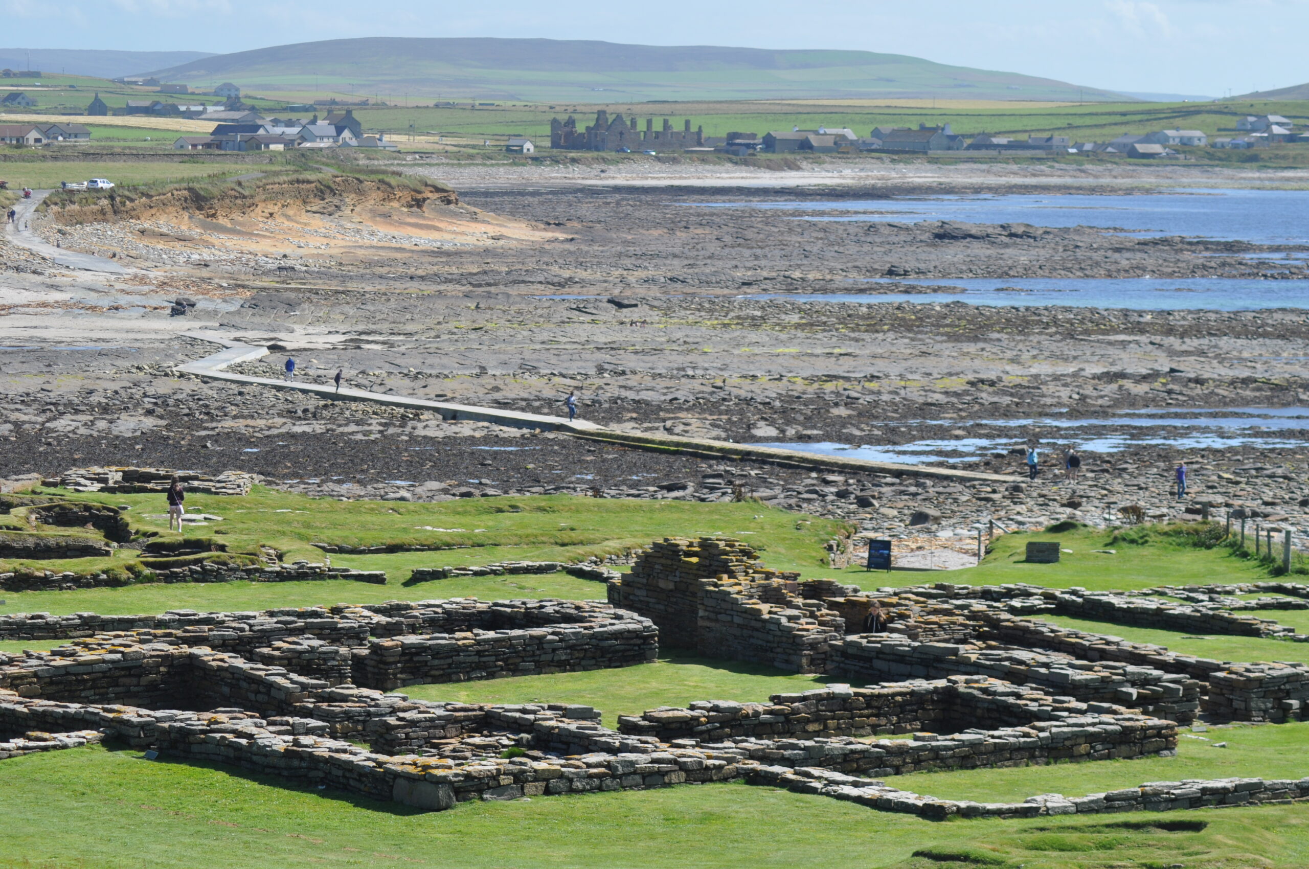 Photo of a tidal island (with the causeway in the background, and the remains of medieval buildings in the foreground