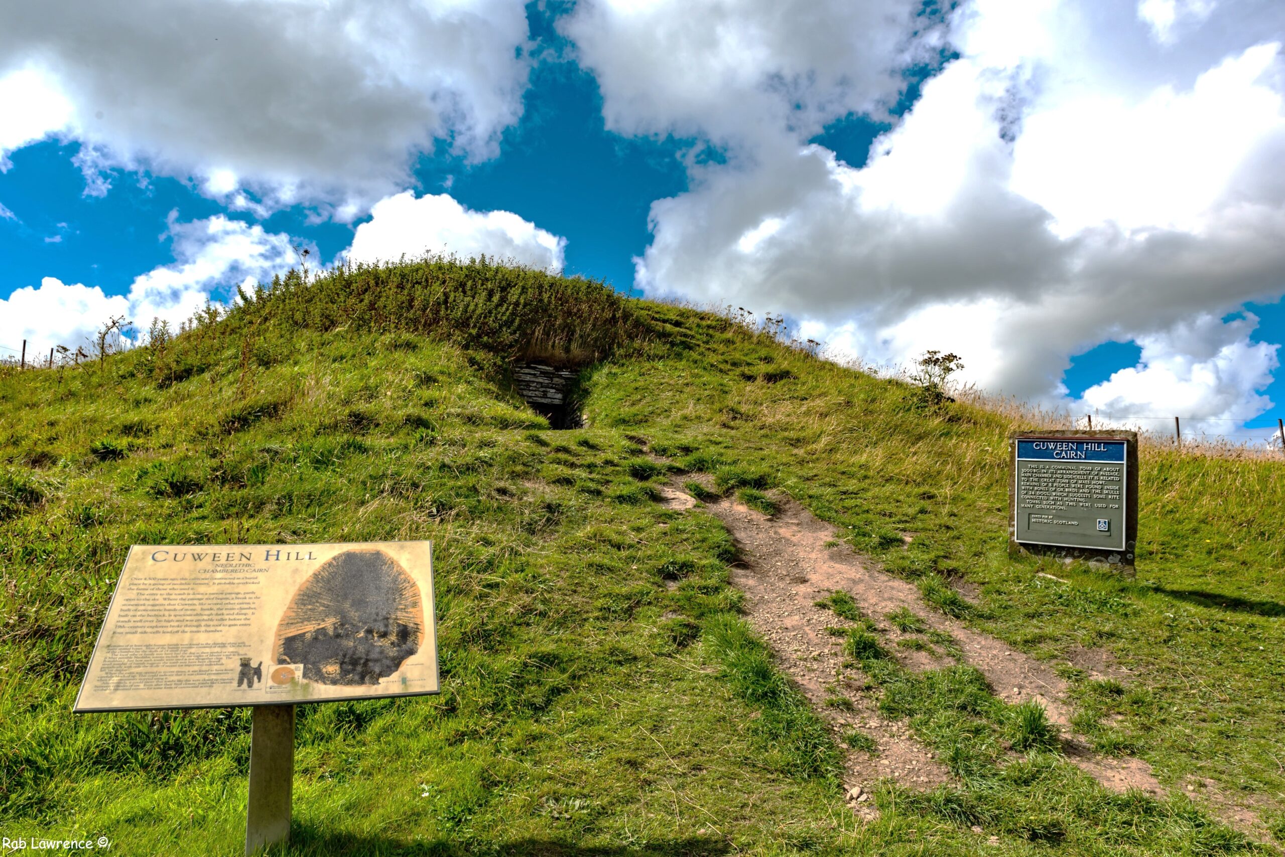 Photo of the exterior of a chambered cairn covered in turf