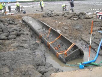 Photo of a huge wooden logboat exposed after laying dormant in mudflats for thousands of years
