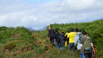 People walking in a wild area with mountains in background