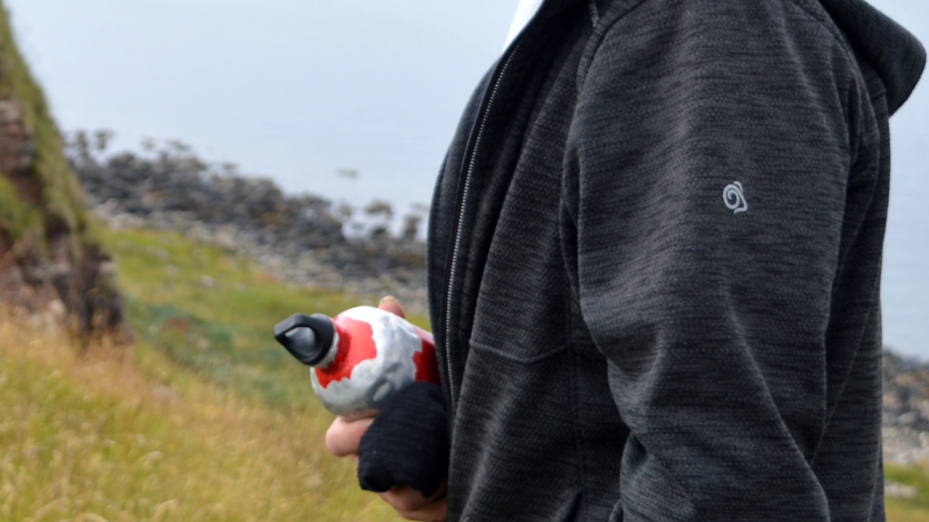 Person holding a reusable water bottle outdoors