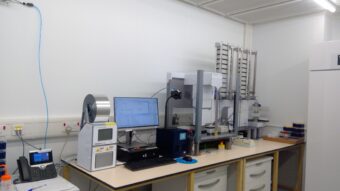 Photo of a lab with a computer and microscope on a desk