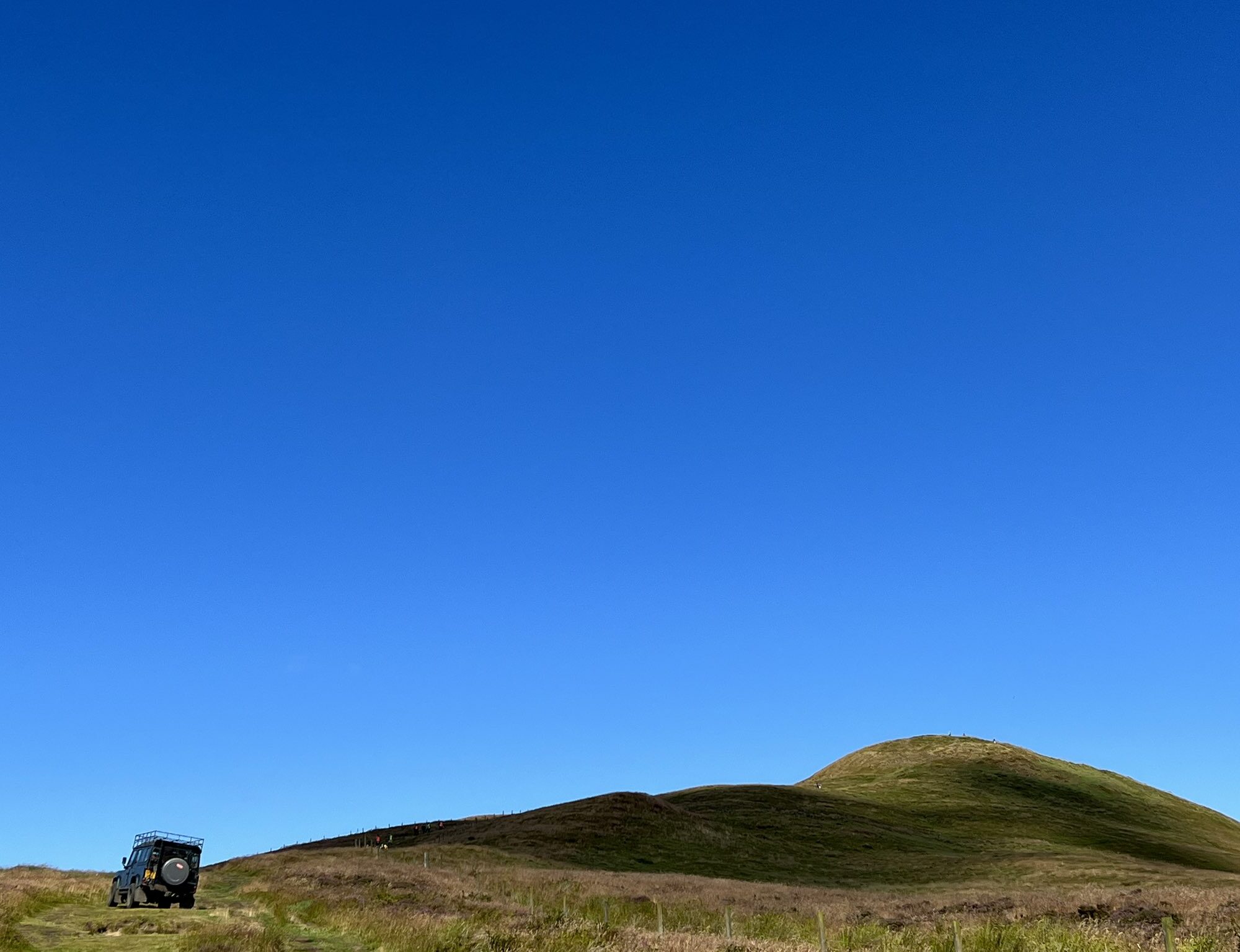 Photo of a hill under a clear blue sky