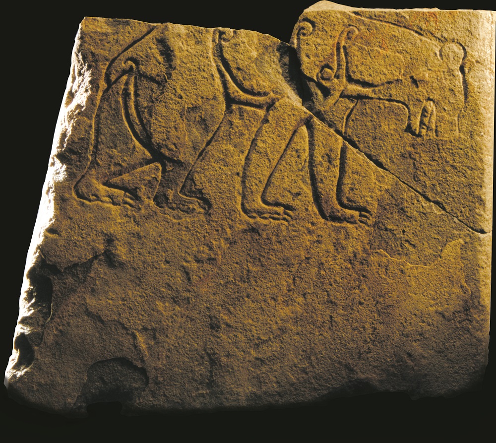 Photo of a carved stone featuring a prowling bear