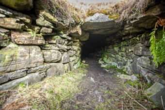 Photo of a square stone opening of an underground passage