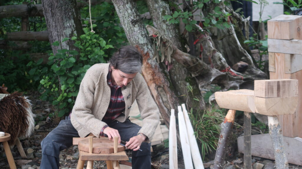 Person working with wood in a forested area