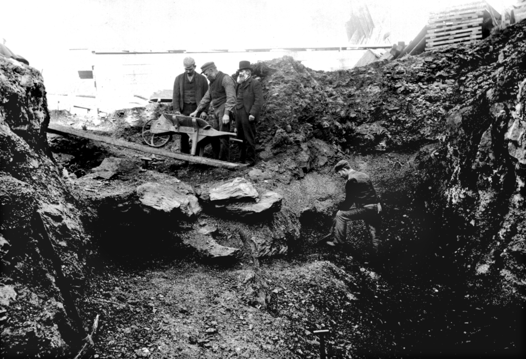 Black and white photo of men in the 19th century excavating a cave
