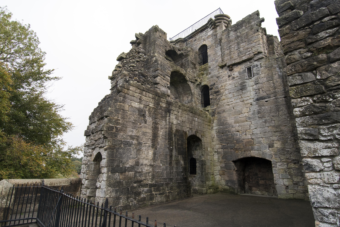 Photo of a grey, stone-built gloomy abandoned medieval castle