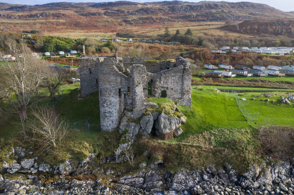 Photo of a ruined medieval castle on a rise by a loch