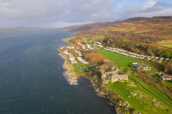 Aerial photo of a stone-built castle on the edge of a huge loch