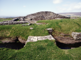 Photo of the low, stone remains of a medieval castle, taken from the old entrance