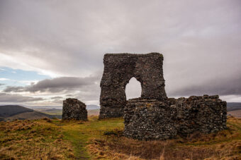 Photo of the stone remains of a medieval arch on top of a hill