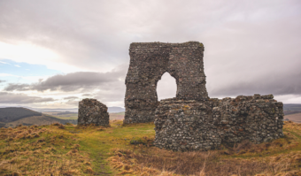 Photo of the stone remains of a medieval arch on top of a hill