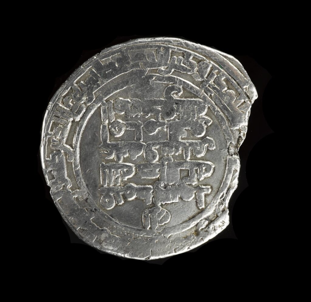 Chipped silver coin with symbols on it