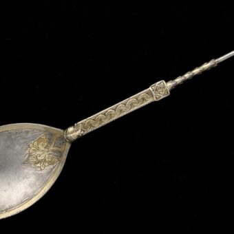 Photo of a finely decorated silver spoon on a black background