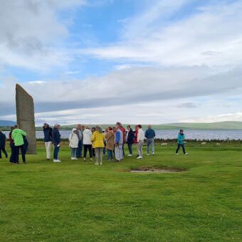 Several people standing around three tall stones