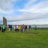 Several people standing around three tall stones