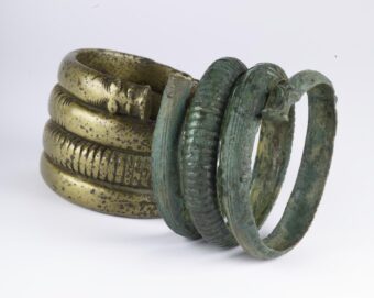 Two spiral armlets with animal heads at the end - one is green and one is gold