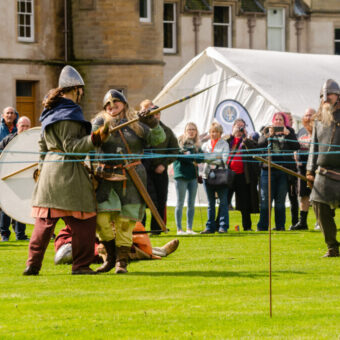 People in historic costumes fighting