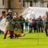 People in historic costumes fighting