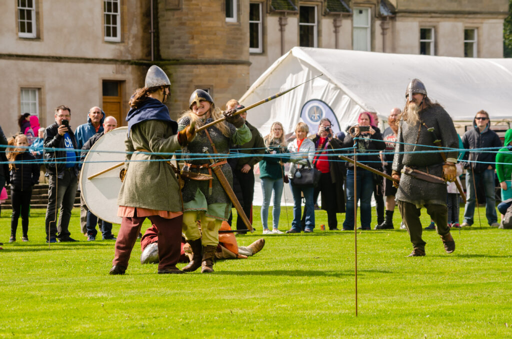 People in historic costumes fighting