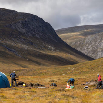 Archaeological dig taking place in a mountainous landscape