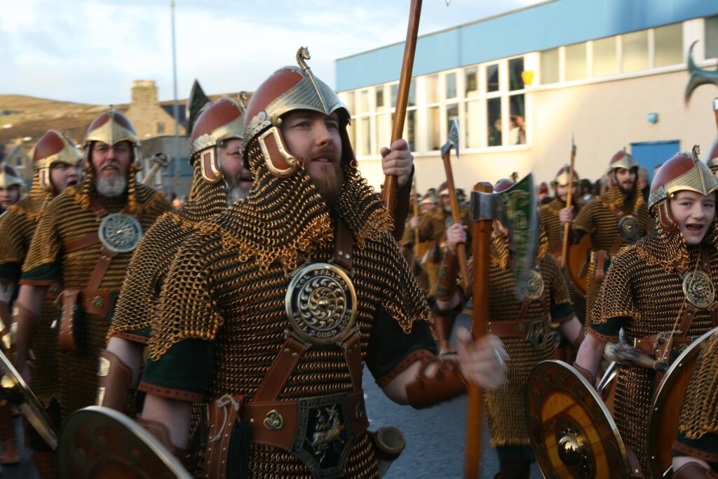 Photo of a group of adult and child Viking reenactors at a performance outside a school