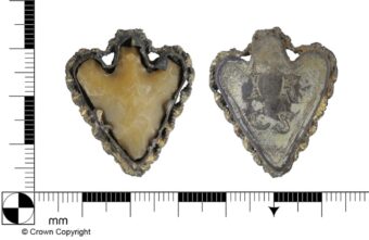 It is a frame and backplate of silver gilt decorative metalwork around a Bronze Age barbed and tanged flint arrowhead. The back of the frame is engraved with the initials I K(or perhaps R) and C S with a small floral embellishment below. The pendant dates to the Post-Medieval period, but the flint is much older, dating to the Early Bronze Age.