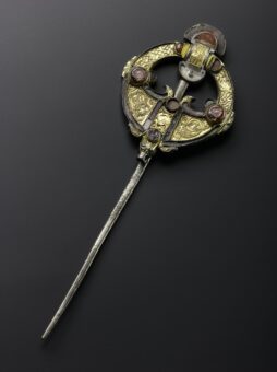 Photo of a large, gold ornate brooch pin