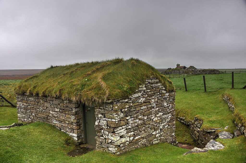 The mill is constructed with drystone walls and roofed with flagstones and turf. The design avoids the use of complicated gearing to transfer the drive to the millstones by mounting the stones directly above the wheel and on the same shaft.