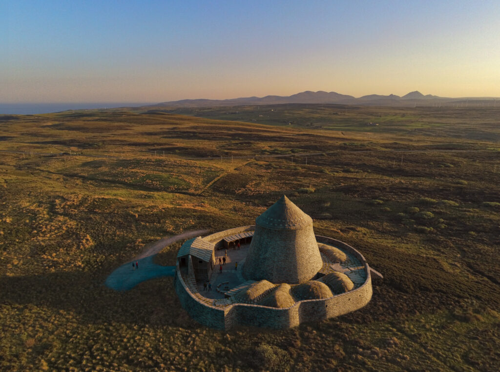 Digital reconstruction of an Iron Age circular tower with several other smaller structures beside it, enclosed by a circular wall