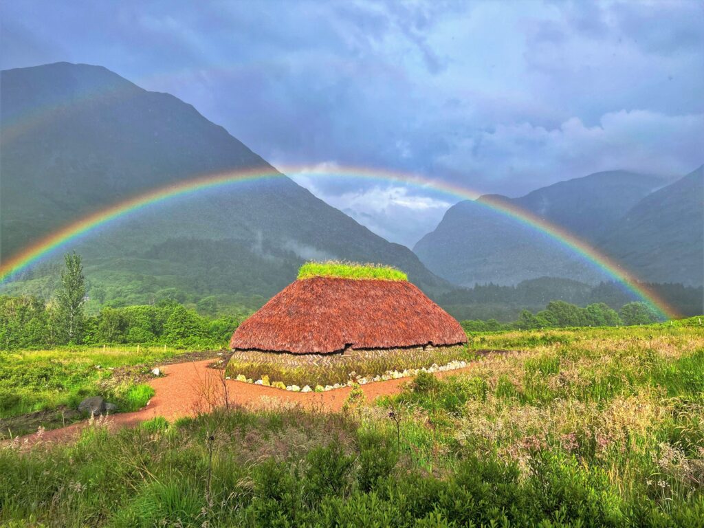 Photograph of a rainbow over a house made using historic materials