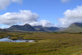 A vast area of peat bog with mountains in the background