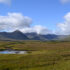 A vast area of peat bog with mountains in the background