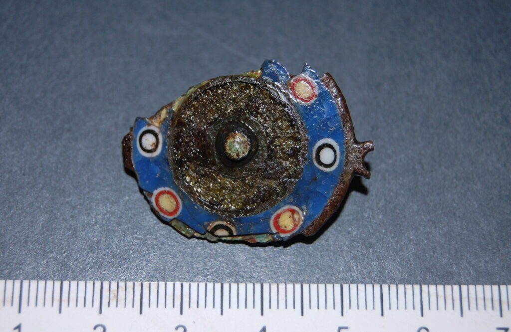 Photo of a brightly coloured piece of a round brooch