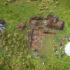 Aerial photo of an archaeological dig showing open shallow trenches and a round tent