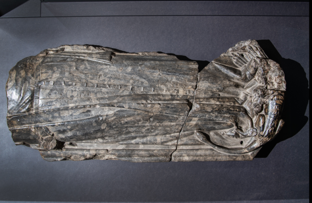 Old statue of a person wearing a robe with no head