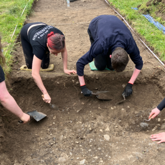 Four people excavating a trench