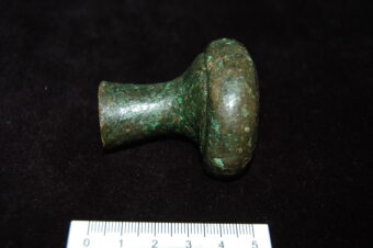 A doorknob-shaped, green metal spearbutt