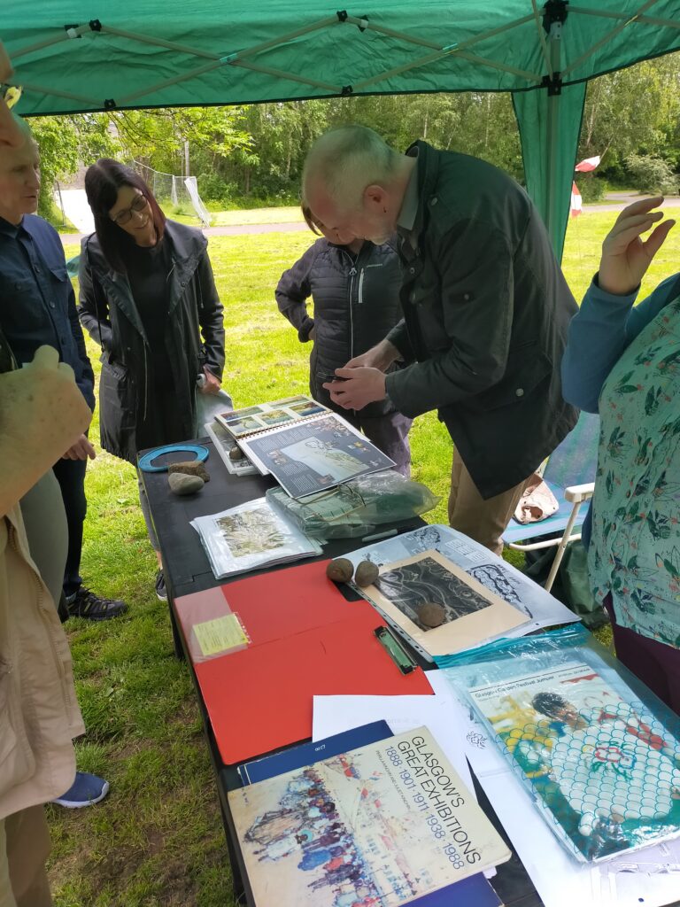 Members of the public looking at Glasgow Garden Festival memorabilia and sharing their own photos during an excavation open day