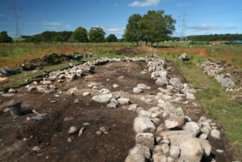 Photo of the stone remains of a medieval farm building in a field