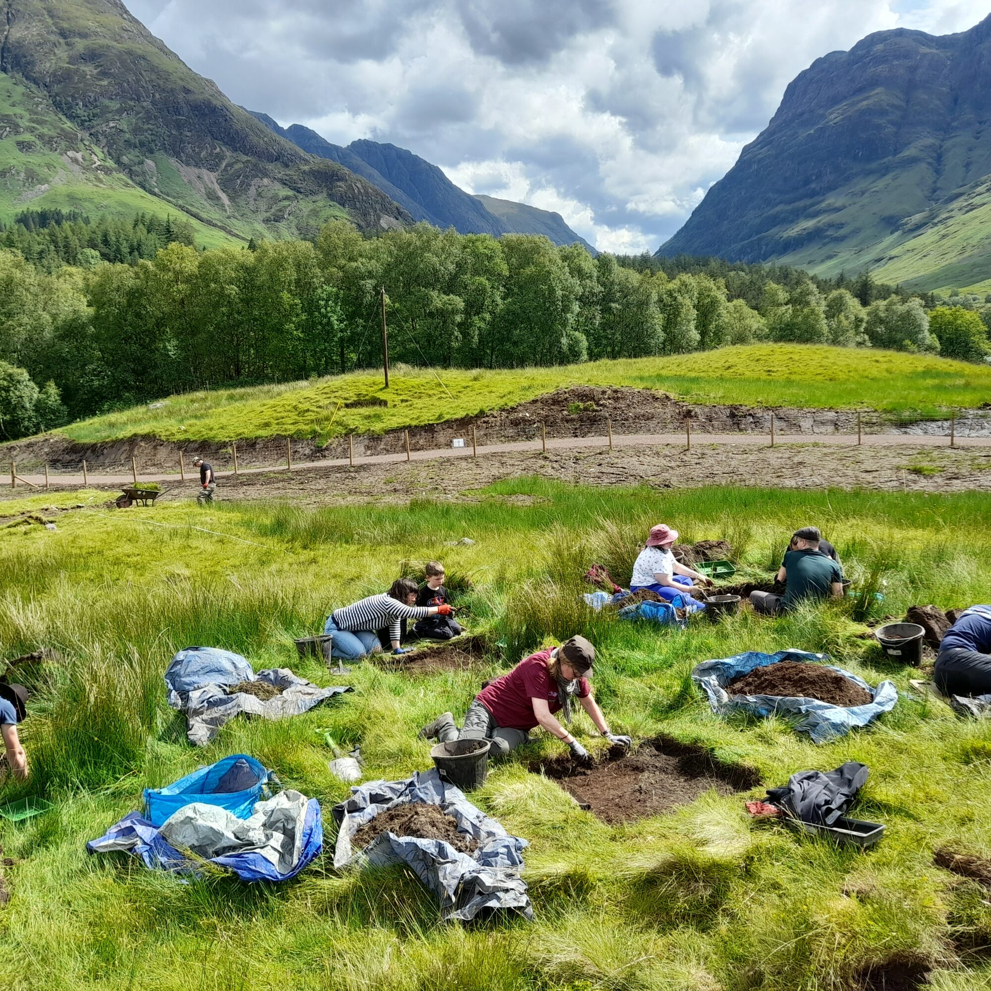 Participants digging with mountains in the background