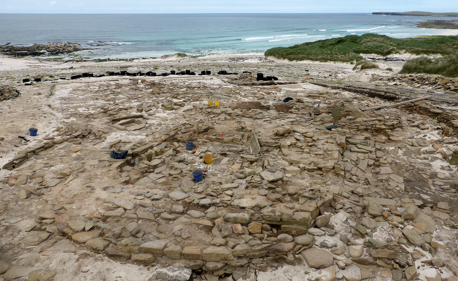 Large excavation of stone structures on a beach