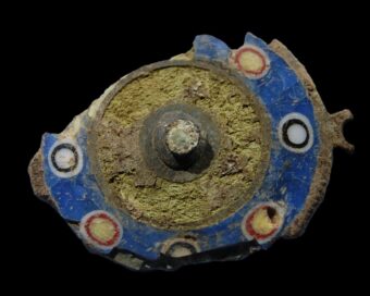 Photo of a brightly coloured piece of a round brooch