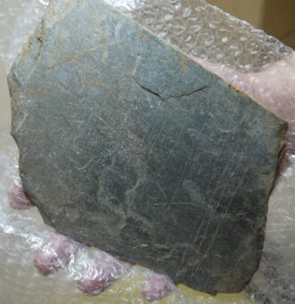 Photo of a flat piece of slate carved with thin straight lines forming a gaming board.