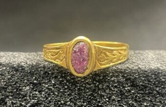 Photo of a gold ring with a pink oval-shaped stone